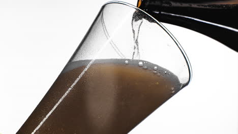 Close-up-background-of-pouring-beer-with-bubbles-and-foam-in-glass-low-angle-side-view-slow-motion